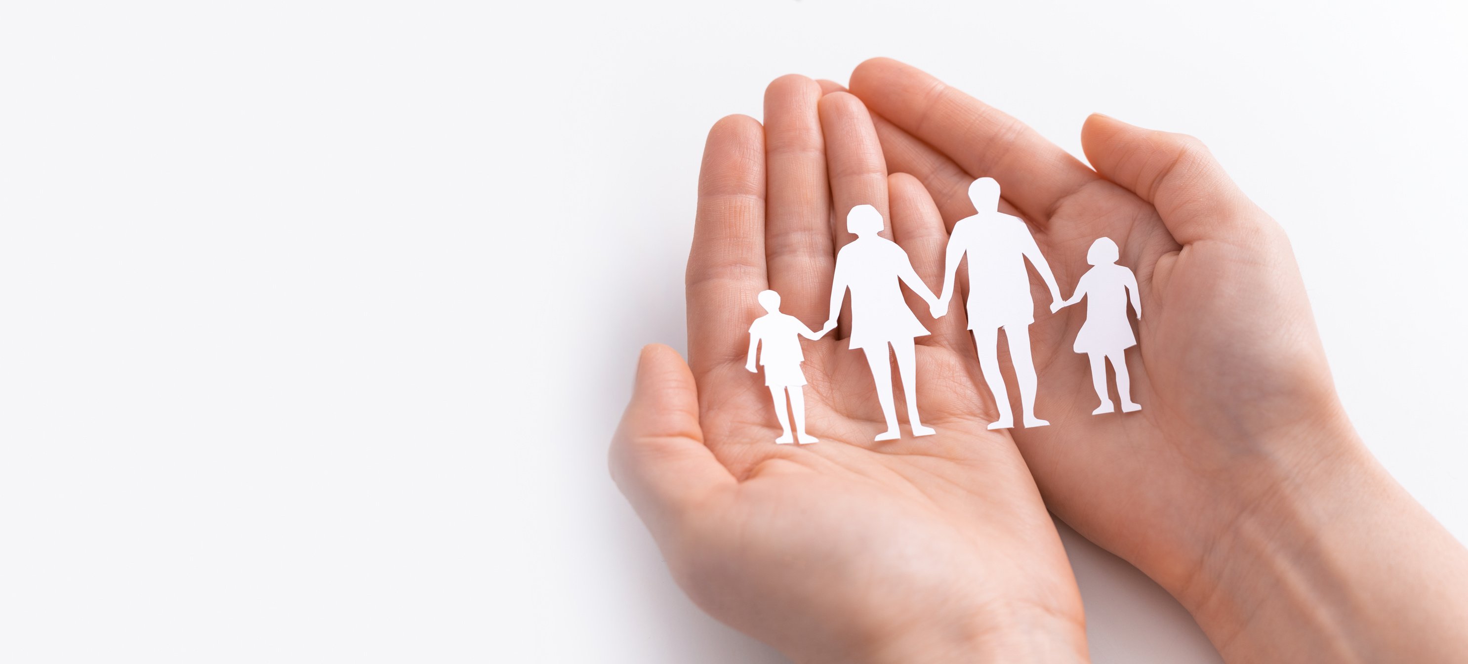 Hands Holding Paper Family Figure on White Background